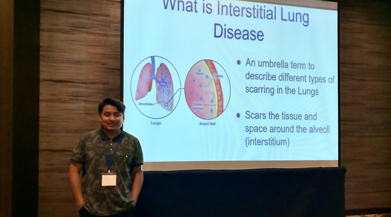 Student in front of a presentation screen titled "What is Interstitial Lung Disease?"