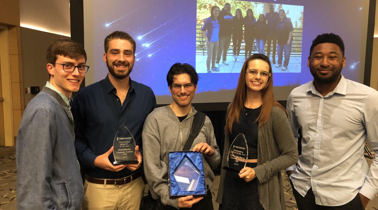 Five students posing, holding three crystal awards