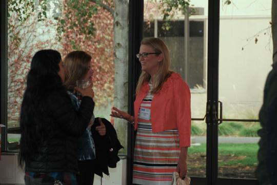 Three people standing by a window, talking